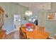Open dining area with wood floors, chandelier, and views into the kitchen and living room at 2216 W Del Webb Blvd, Sun City Center, FL 33573