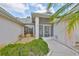 Entryway to home with a screened in front porch, tiled walk way and garden featuring a variety of plants at 2216 W Del Webb Blvd, Sun City Center, FL 33573