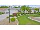 Charming home with a manicured front yard and lush landscaping, including palm trees and decorative shrubbery at 2216 W Del Webb Blvd, Sun City Center, FL 33573