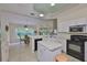 Eat-in kitchen featuring an island, black appliances, and a bright eating nook at 2216 W Del Webb Blvd, Sun City Center, FL 33573