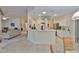 Well-lit kitchen with an island, white cabinets, and a view of the living area at 2216 W Del Webb Blvd, Sun City Center, FL 33573