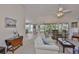 Comfortable seating arrangement and abundant natural light fills the living room, connecting the dining area and sunroom at 2216 W Del Webb Blvd, Sun City Center, FL 33573