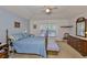 Cozy main bedroom featuring a wooden four-poster bed, dresser, and a light blue accent wall at 2216 W Del Webb Blvd, Sun City Center, FL 33573