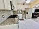 Modern kitchen featuring white cabinets, stainless steel appliances, and granite countertops at 2457 Ecuadorian Way # 57, Clearwater, FL 33763