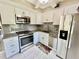 Well-equipped kitchen showcasing stainless steel appliances, ample counter space, and tiled floors at 2457 Ecuadorian Way # 57, Clearwater, FL 33763