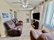 Comfortable living room featuring reclining leather sofas, a ceiling fan, and natural light at 2457 Ecuadorian Way # 57, Clearwater, FL 33763
