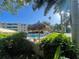 A sunny view of the community pool, featuring tiki umbrellas and lounge chairs for relaxation at 2615 Cove Cay Dr # 408, Clearwater, FL 33760