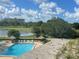 Scenic view of a pool, lake, lush landscaping, and community buildings with a beautiful sky at 2615 Cove Cay Dr # 408, Clearwater, FL 33760
