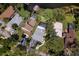 Aerial view showcasing waterfront homes and lush landscaping, highlighting a serene swimming pool and ample parking at 297 Lakeview Dr, Tarpon Springs, FL 34689