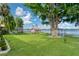 Expansive backyard with a dock, trees, lush green lawn, and access to waterfront views at 297 Lakeview Dr, Tarpon Springs, FL 34689