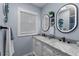 Stylish bathroom featuring a double vanity with marble countertops, modern mirrors, and elegant fixtures at 297 Lakeview Dr, Tarpon Springs, FL 34689