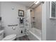 Bathroom with tiled shower and jacuzzi tub, featuring a shower curtain, toilet with accessibility bar, and wall art at 297 Lakeview Dr, Tarpon Springs, FL 34689