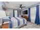 Comfortable bedroom with blue accents, a ceiling fan, and ample natural light from the large windows at 297 Lakeview Dr, Tarpon Springs, FL 34689
