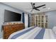 Spacious bedroom with a ceiling fan, large windows, and ample storage with built-in display cabinets at 297 Lakeview Dr, Tarpon Springs, FL 34689