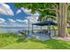 Inviting dock featuring a covered seating area, picnic table, and swing, perfect for lakeside relaxation at 297 Lakeview Dr, Tarpon Springs, FL 34689