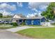 Lovely home featuring a well-manicured lawn and driveway, with a partial view of the adjacent lake at 297 Lakeview Dr, Tarpon Springs, FL 34689