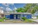 Charming single-story home featuring a bright blue exterior, covered parking, and well-maintained landscaping at 297 Lakeview Dr, Tarpon Springs, FL 34689