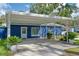 Charming blue home with a covered carport, well-maintained landscaping, and inviting curb appeal at 297 Lakeview Dr, Tarpon Springs, FL 34689