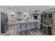 Bright kitchen with white cabinets, stainless steel appliances, quartz countertops, and bar stool seating at 297 Lakeview Dr, Tarpon Springs, FL 34689