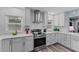 Modern kitchen with stainless steel appliances, beautiful gray cabinets, and white countertops and backsplash at 297 Lakeview Dr, Tarpon Springs, FL 34689