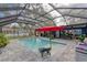 Inviting screened-in pool with a red umbrella, surrounded by comfortable seating and overlooking a beautiful lake at 297 Lakeview Dr, Tarpon Springs, FL 34689