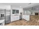 Modern kitchen with stainless steel appliances and white cabinets, flowing into the living area at 3079 Osprey Ln, Clearwater, FL 33762