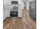 Close-up view of the modern kitchen with stainless steel appliances and wood-look tile flooring at 3079 Osprey Ln, Clearwater, FL 33762