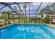 Enclosed pool showcases pavers, landscaping, and black-framed screened enclosure at 3079 Osprey Ln, Clearwater, FL 33762
