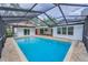 Enclosed pool boasts pavers, ladder, adjacent patio, mature landscaping, and privacy at 3079 Osprey Ln, Clearwater, FL 33762