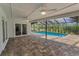 Screened in pool with brick paver deck surrounded by mature landscaping at 3079 Osprey Ln, Clearwater, FL 33762