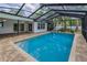 A beautiful screened-in pool with brick pavers and a light-colored tile trim offers a relaxing and private outdoor space at 3079 Osprey Ln, Clearwater, FL 33762