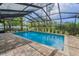 Enclosed pool boasts pavers, landscaping, and black-framed screened enclosure at 3079 Osprey Ln, Clearwater, FL 33762