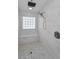 Tiled walk-in shower featuring a glass block window and rainfall showerhead at 3079 Osprey Ln, Clearwater, FL 33762