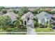 Tan two-story home in a neighborhood setting, featuring lush landscaping and a well-maintained lawn at 30817 Pumpkin Ridge Dr, Wesley Chapel, FL 33543