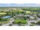 Aerial view of community clubhouse, pool and tennis courts surrounded by lush landscaping and trees at 30817 Pumpkin Ridge Dr, Wesley Chapel, FL 33543