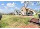 Large backyard with well-maintained lawn and patio area with seating and BBQ grill, surrounded by trees at 30817 Pumpkin Ridge Dr, Wesley Chapel, FL 33543