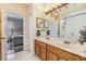Bright bathroom featuring a double vanity with marble countertops and wood cabinets, with an adjoining bedroom at 30817 Pumpkin Ridge Dr, Wesley Chapel, FL 33543