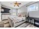 Neutral bedroom featuring a tufted headboard, a ceiling fan, and an arched window providing natural light at 30817 Pumpkin Ridge Dr, Wesley Chapel, FL 33543