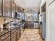 Well-equipped kitchen featuring dark wood cabinetry, granite countertops, stainless steel appliances, and a view to dining at 30817 Pumpkin Ridge Dr, Wesley Chapel, FL 33543