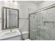 Bright bathroom featuring a marble tiled shower with glass door and a vanity with a modern framed mirror at 3101 4Th N Ter, St Petersburg, FL 33713
