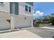 Townhome exterior featuring a garage door, neutral paint, and a blue-green trim under a sunny sky at 3101 4Th N Ter, St Petersburg, FL 33713