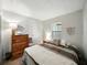 Cozy bedroom with wood-look flooring, dresser, queen bed, and decor at 35149 Wagner Way, Zephyrhills, FL 33541