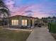 Charming single-story home with covered parking, landscaped yard, and cozy front patio seating area at 35149 Wagner Way, Zephyrhills, FL 33541