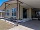 Welcoming exterior featuring a covered patio, updated windows, and a cozy seating area with well-maintained landscaping at 35149 Wagner Way, Zephyrhills, FL 33541