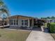 Inviting single-story home with a covered parking area, a well-maintained lawn, and a cozy front patio at 35149 Wagner Way, Zephyrhills, FL 33541