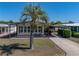 Charming single-story home featuring a covered parking area and manicured lawn with mature landscaping at 35149 Wagner Way, Zephyrhills, FL 33541