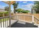 Cozy back porch with wooden railing, and view of the backyard with trees at 3806 N Tampa St, Tampa, FL 33603