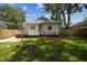 Green backyard with fire pit, landscaping and a view of the back of the home at 3806 N Tampa St, Tampa, FL 33603