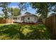 A lovely backyard with a wooden fence, green grass, and a charming home exterior at 3806 N Tampa St, Tampa, FL 33603