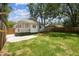 Spacious fenced backyard with green grass, a firepit, landscaping and a view of the home at 3806 N Tampa St, Tampa, FL 33603